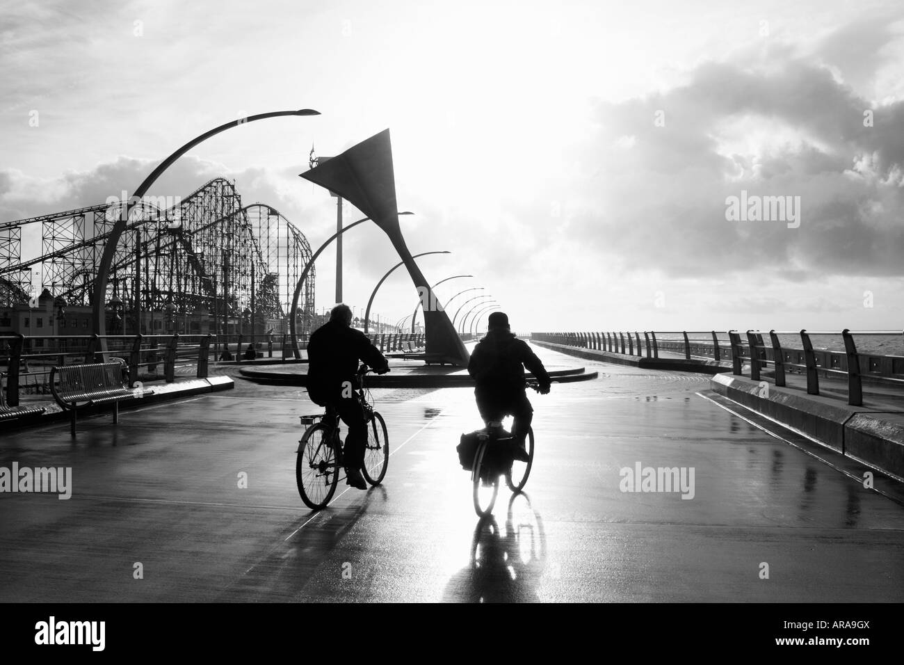 Blackpool England Two cyclists passing Swivelling Wind Shelter sculpture Stock Photo