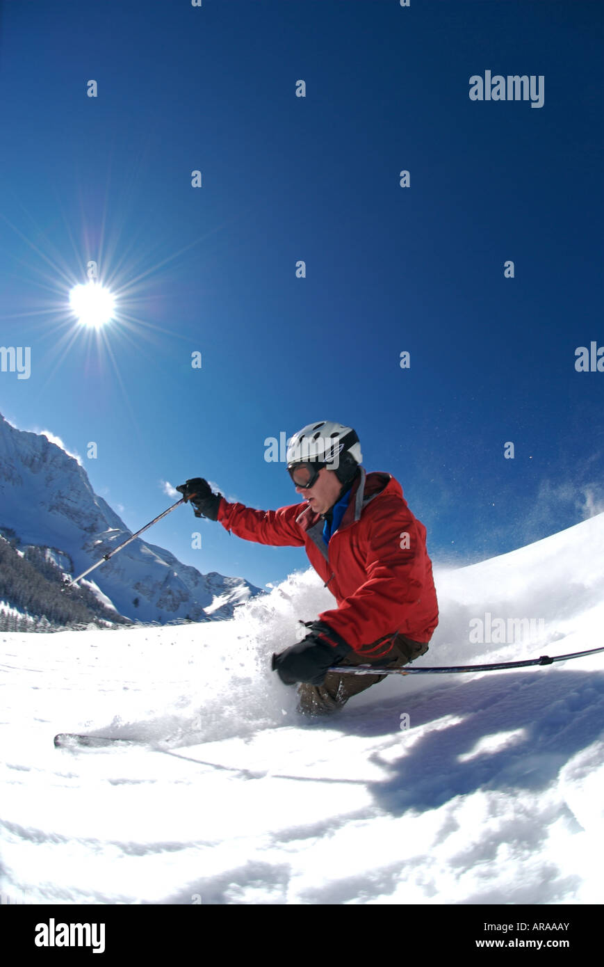 A man skis through deep powder on a sunny day near Telluride Colorado Stock Photo