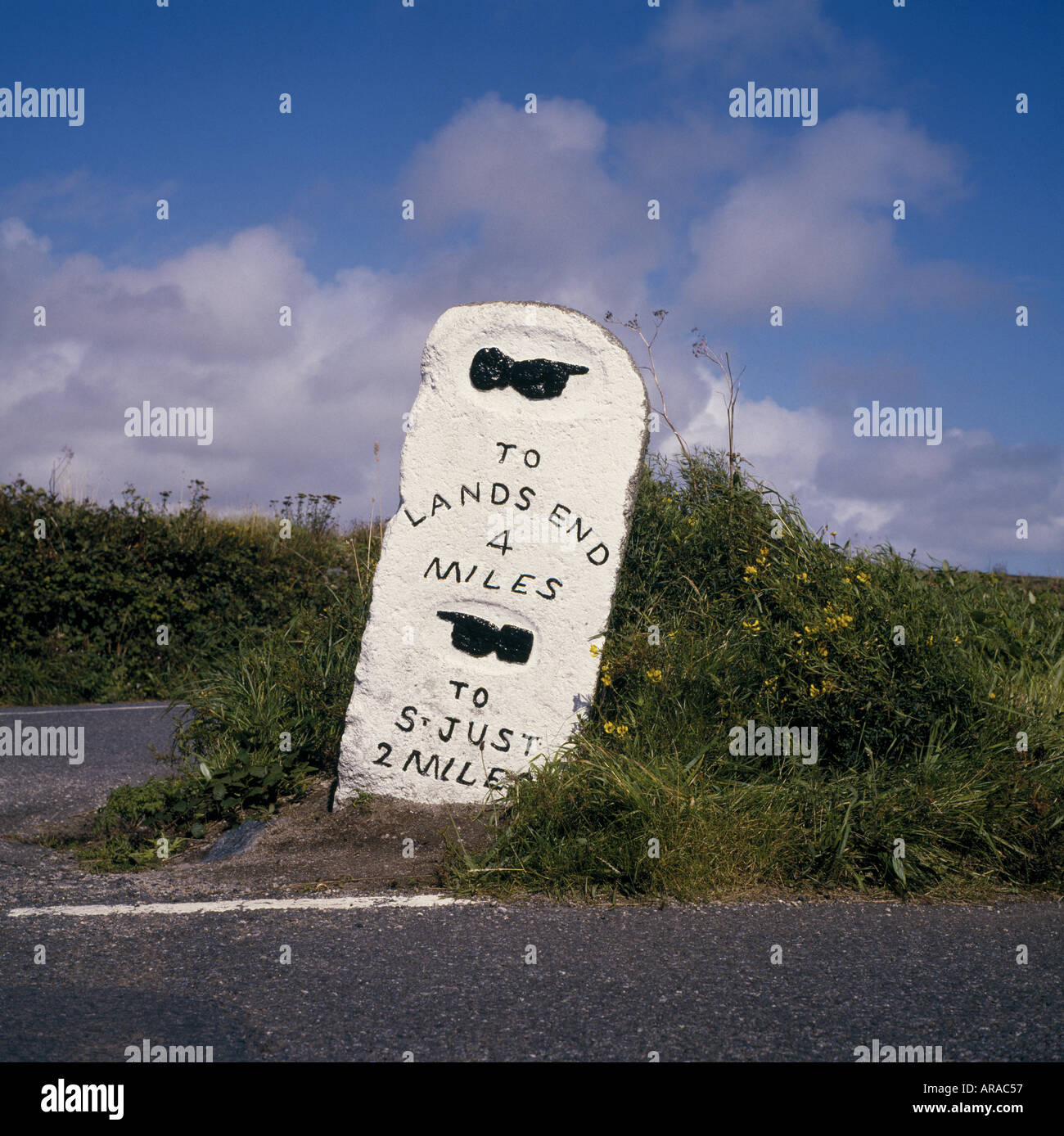 A stone milestone by the roadside at Penwith Cornwall indicating the distance to Lands End and St Just Stock Photo