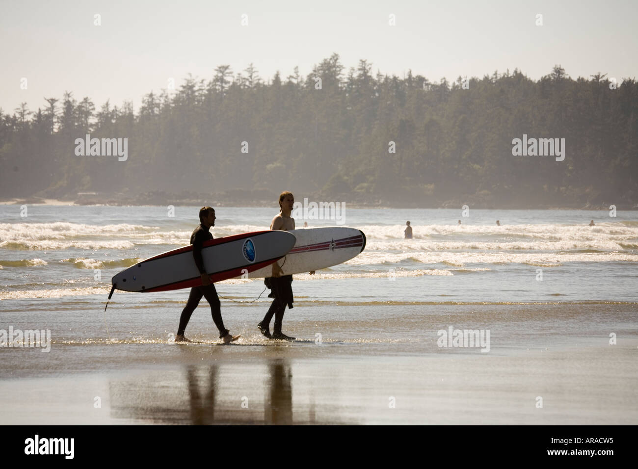 Surfers with boards on Long Beach Pacific Rim national park reserve Vancouver island Canada Stock Photo