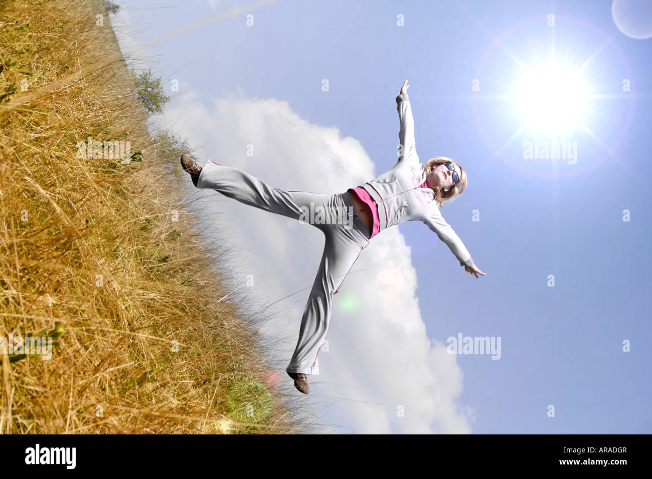 Happy woman jumping against blue sky Stock Photo - Alamy