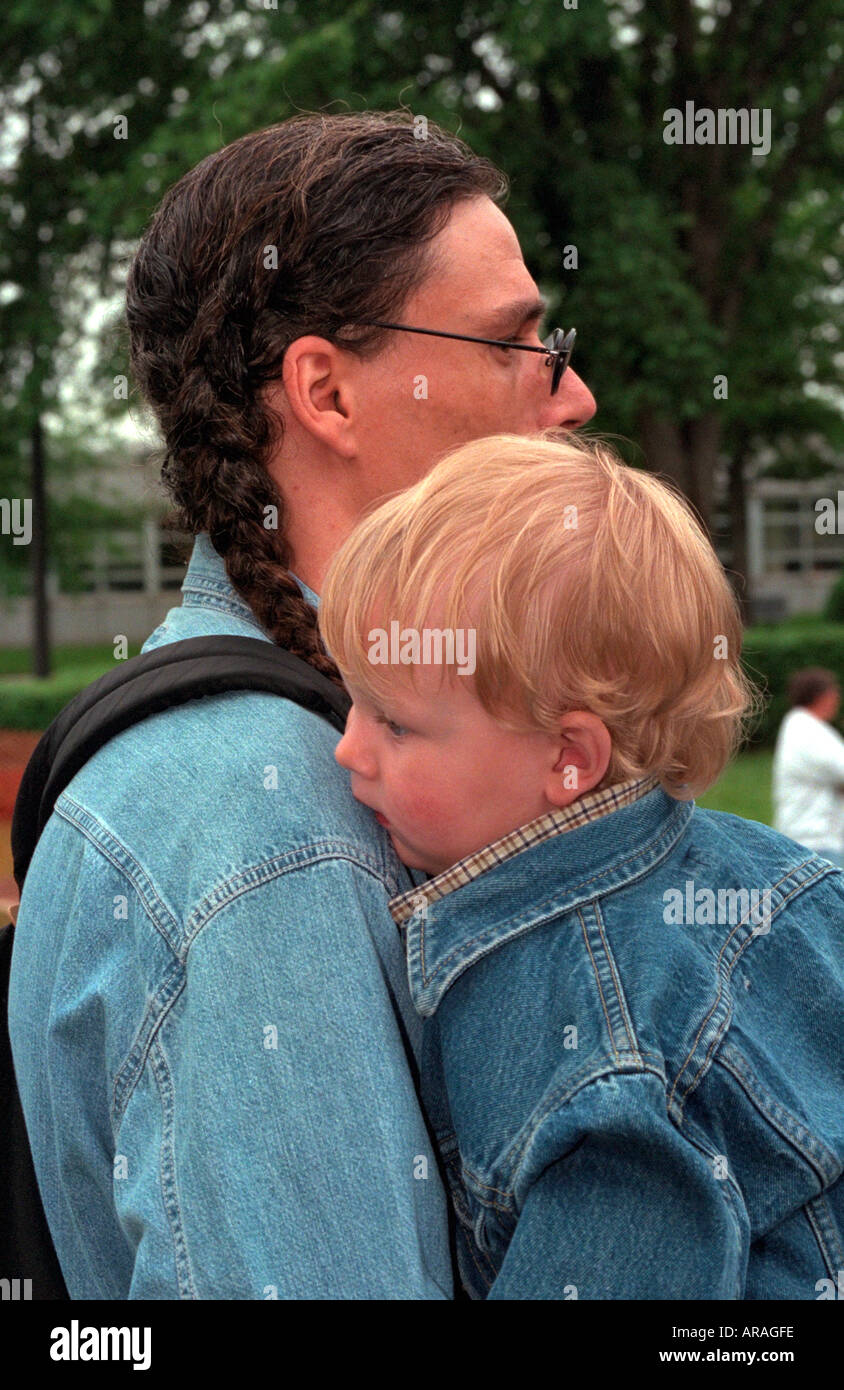 Native American Indian dad holding son age 30 and 2 on Memorial Day . St Paul Minnesota MN USA Stock Photo