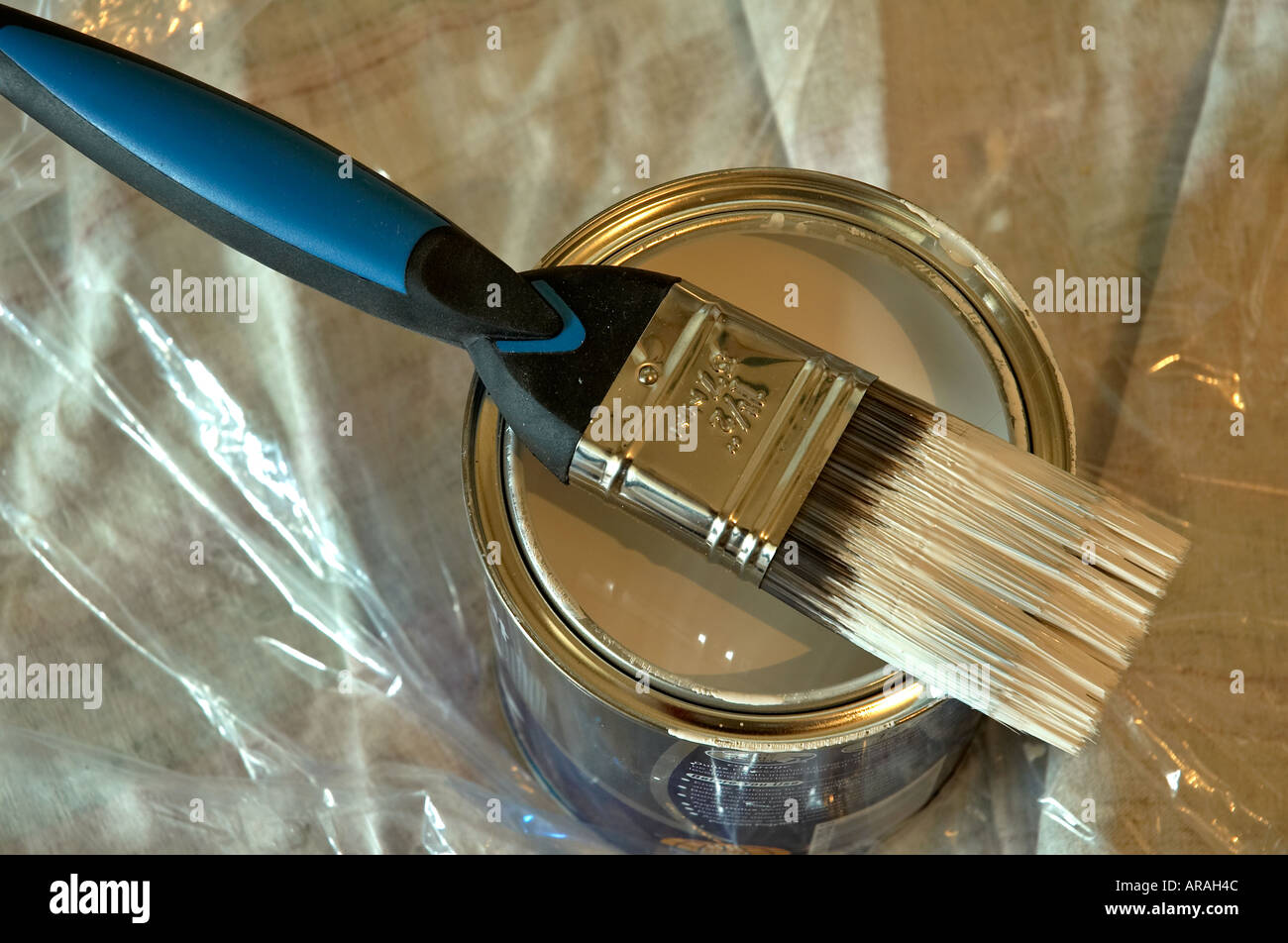 A paint brush loaded with white paint and resting on the top of an open