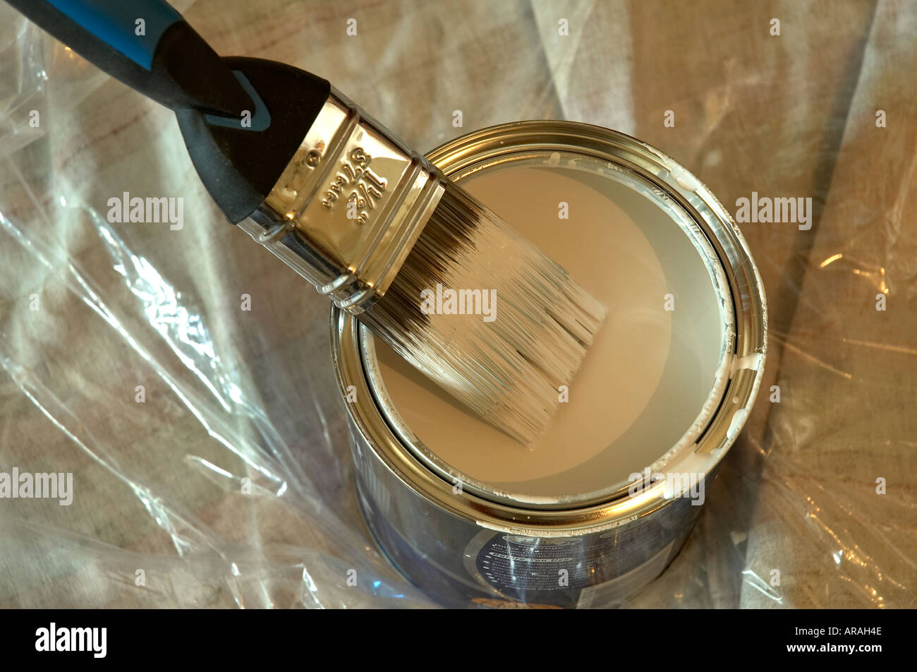 A paint brush loaded with white paint and resting on the top of an open