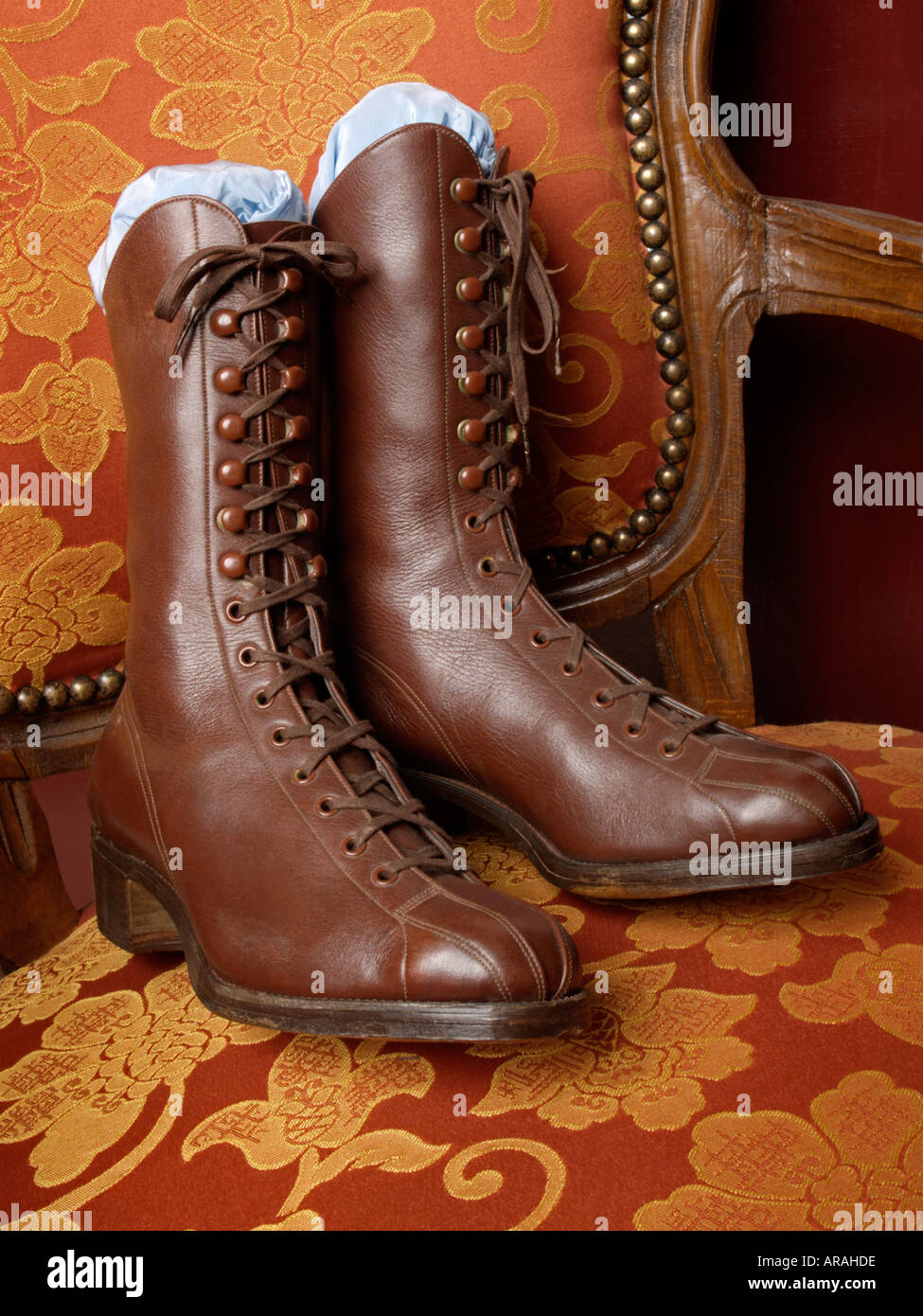 Pair of nostalgic old laced ladies boots shoes on antique chair Stock Photo