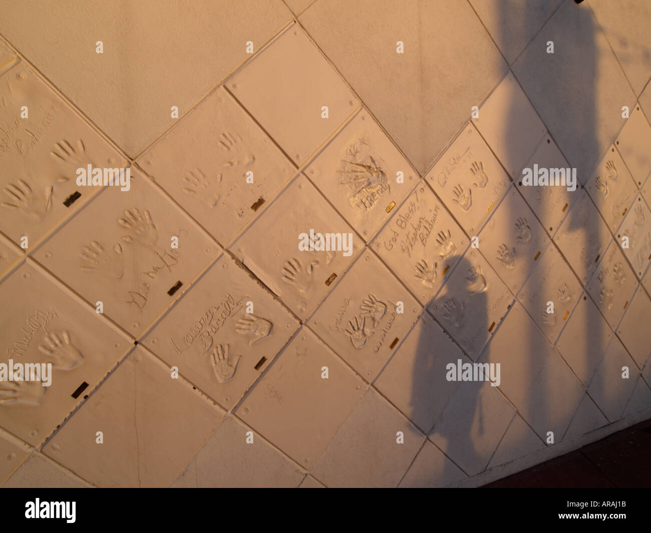 Wall of fame Planet Hollywood restaurant shot in the last sunlight with person s shadow Disney Village Paris France Stock Photo
