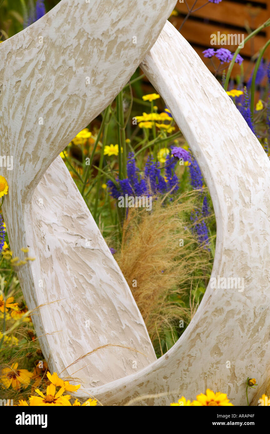 Tatton Flower Show garden sculpture shaped like a figure 8 with Helenium Wyndley and ornamental grasses Stock Photo