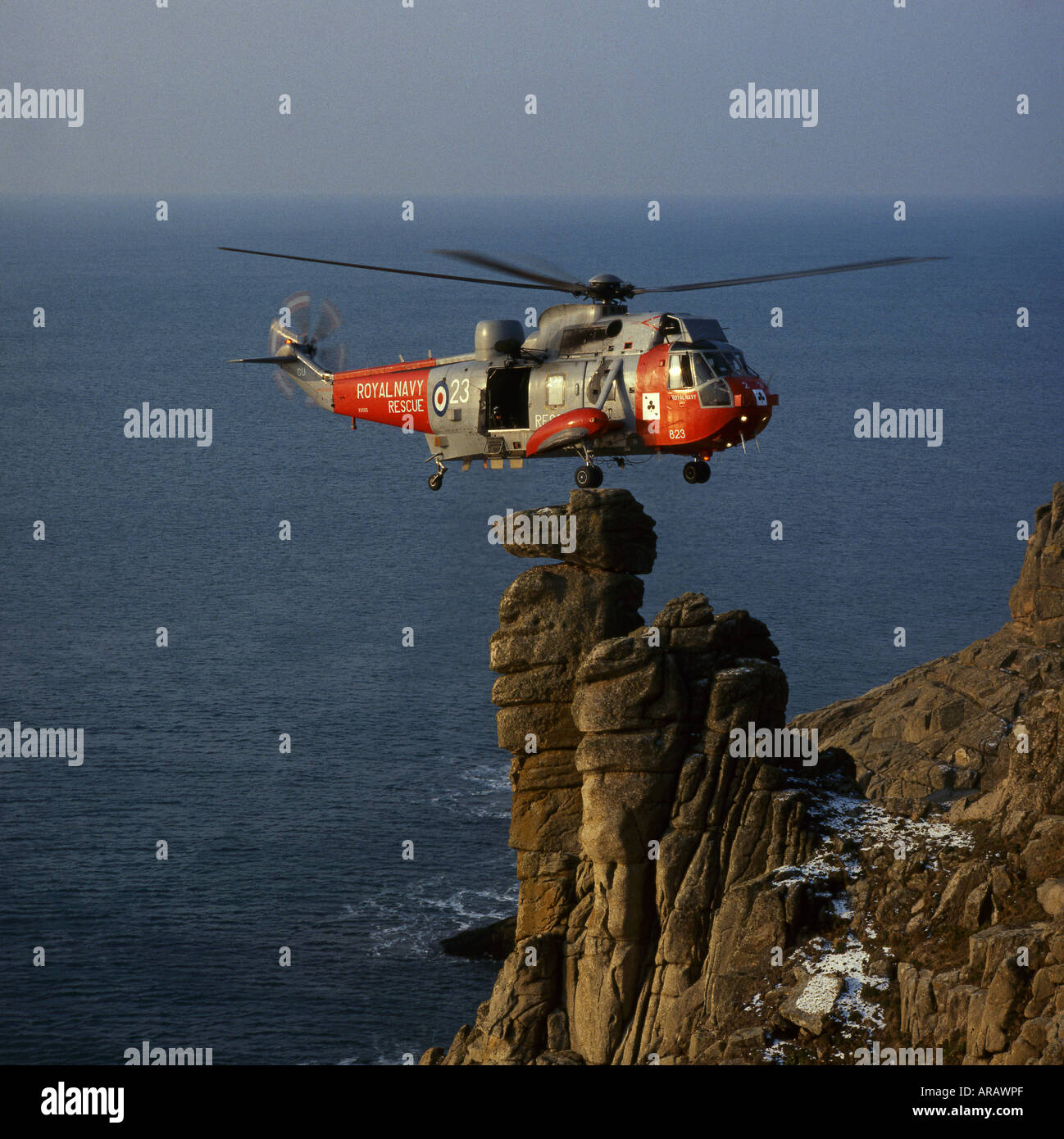 SAR Seaking 5 Helicopter From 771 Royal NAS Balances on  Camel's Head Rock, Rinsey Cliffs, Near Porhleven, Cornwall, England, UK Stock Photo