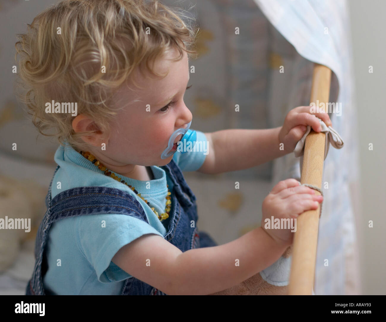 baby standing in cot Stock Photo