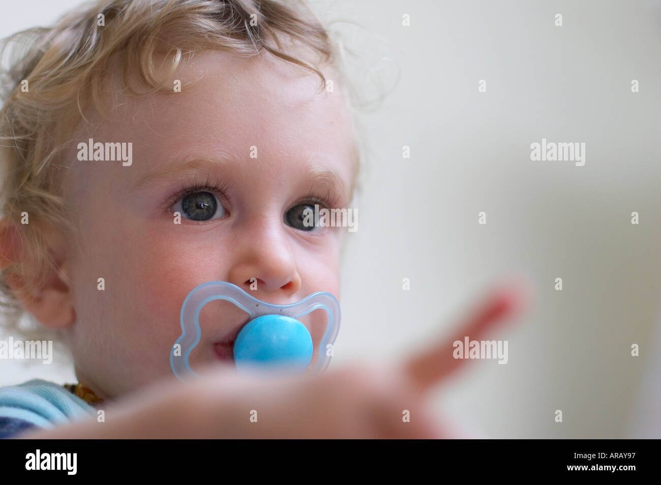 baby with dummy pointing finger at something Stock Photo