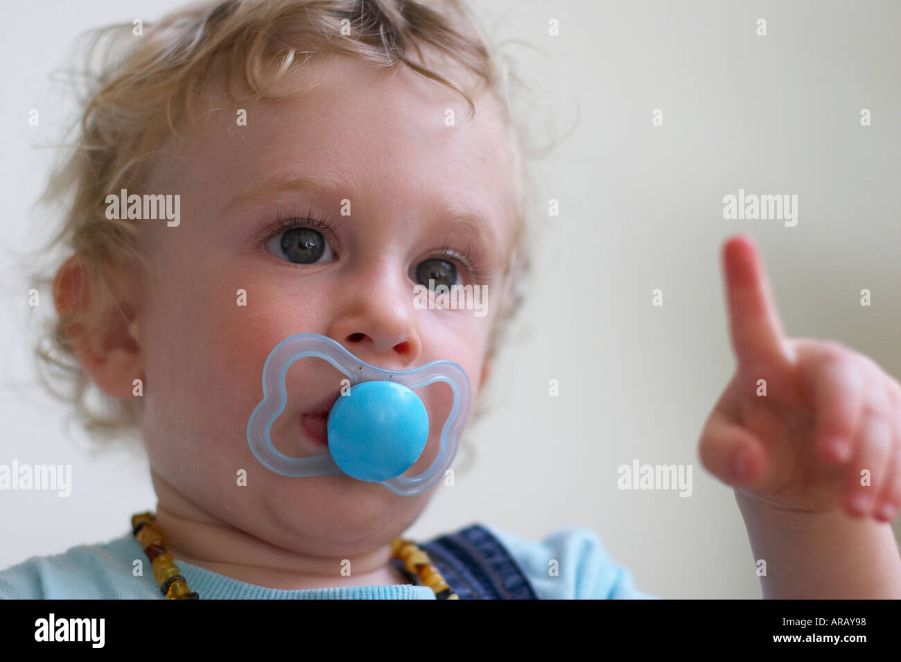 baby with dummy pointing finger at something Stock Photo