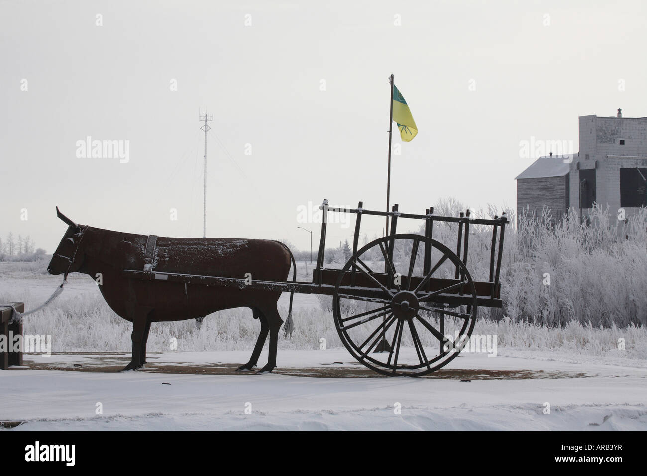 Painet jq5534 ox red river cart aylesbury fake sask flag old elevator statue ornamental snow covered winter frost hoar trees Stock Photo