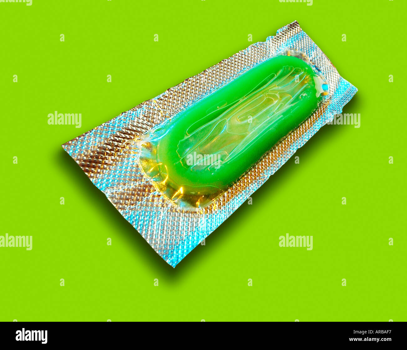 SINGLE GREEN CONDOM IN FOIL WRAPPER ON GREEN BACKGROUND Stock Photo - Alamy