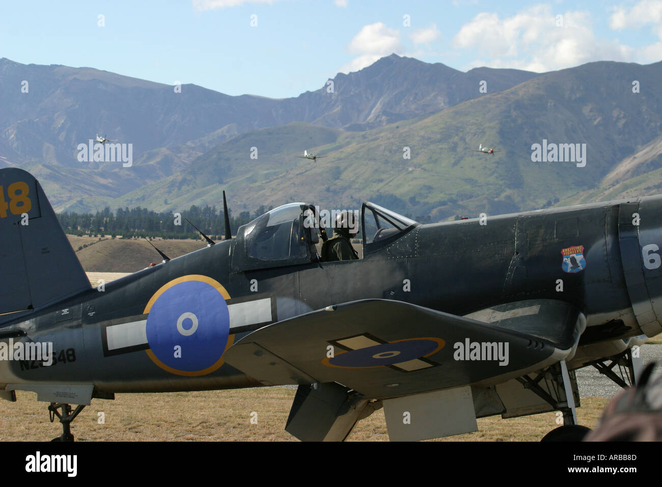 Goodyear Corsair FG 1D whispering death fighter bomber and Mustangs Killtyhawks in distance Stock Photo