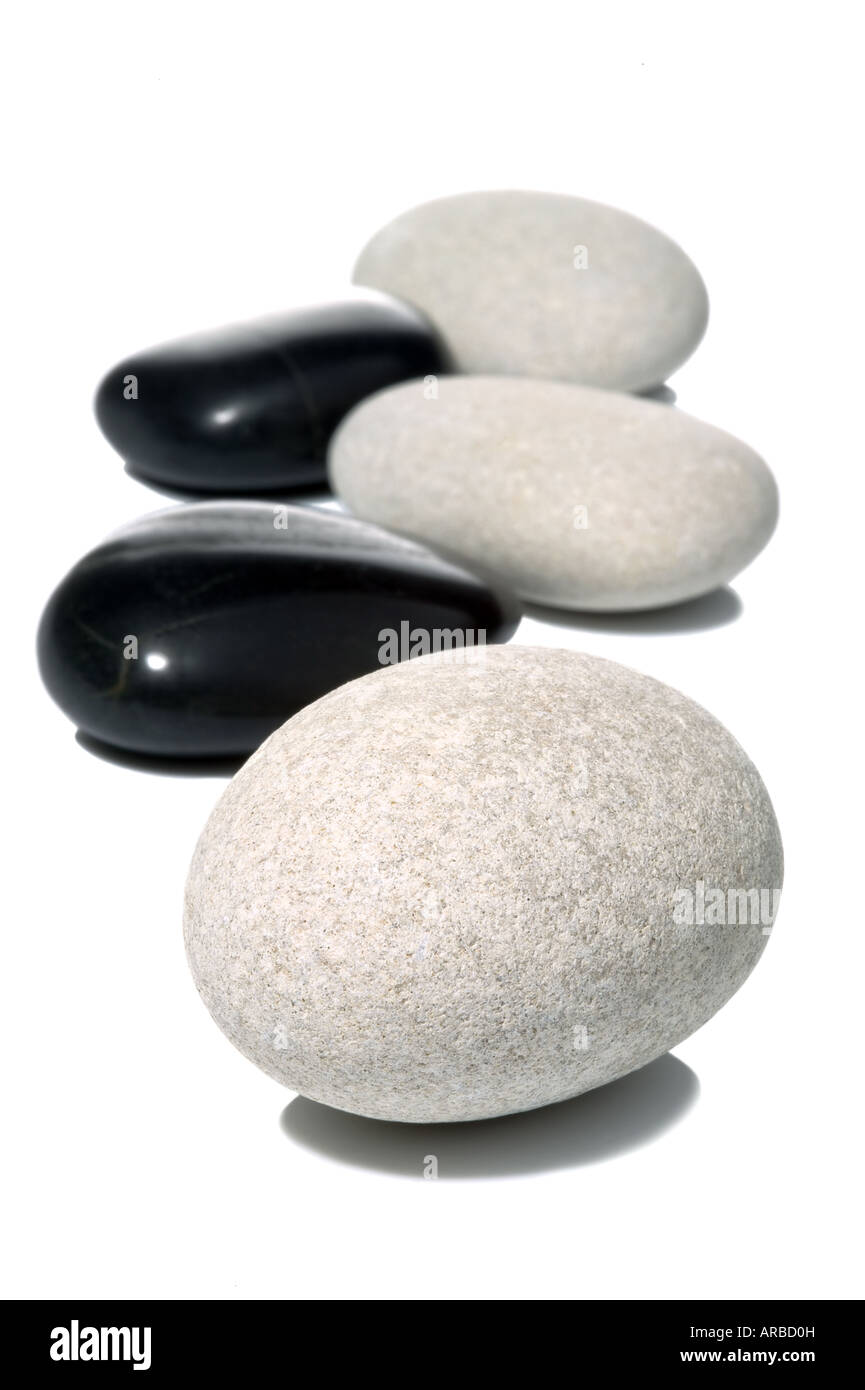 Black and White pebbles on a white surface high key shot with shadows Stock Photo