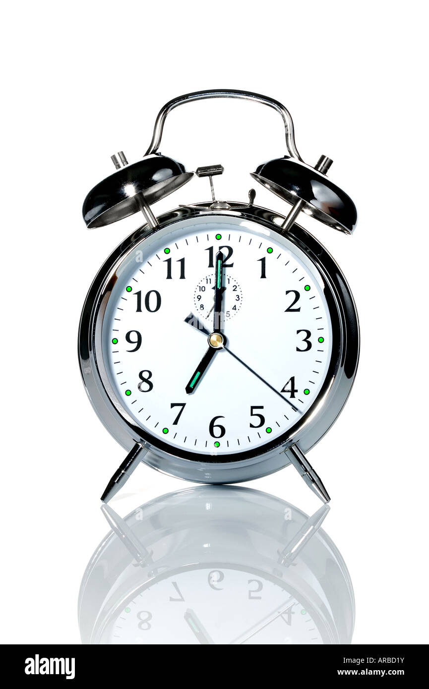 A chrome alarm clock with the hands at 7 o clock Stock Photo Alamy