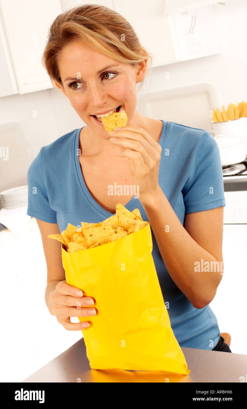 WOMAN EATING TORTILLA CHIPS Stock Photo
