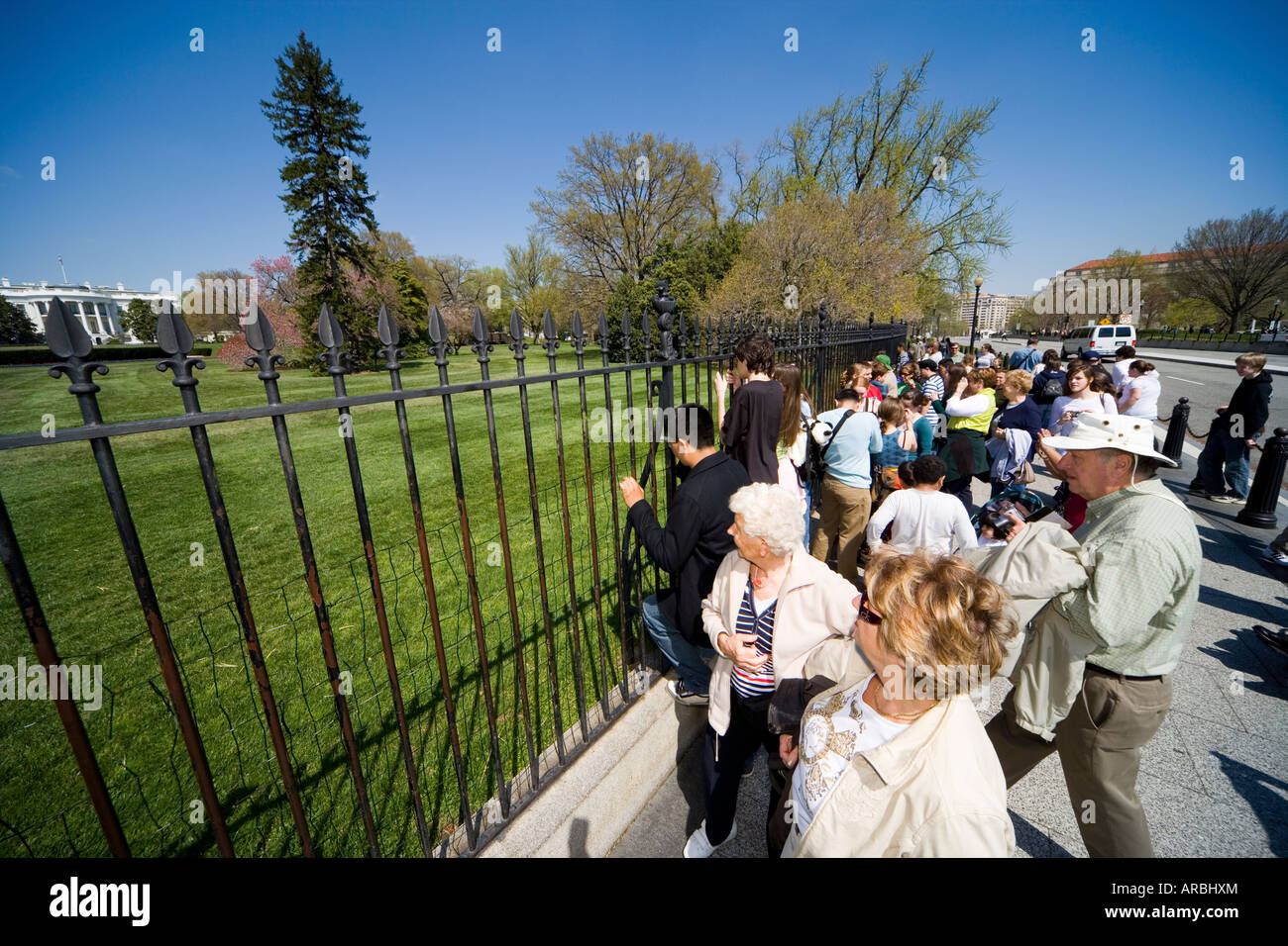 Springtime view of the rear of the White House with tourists taking pictures through the fence. Stock Photo