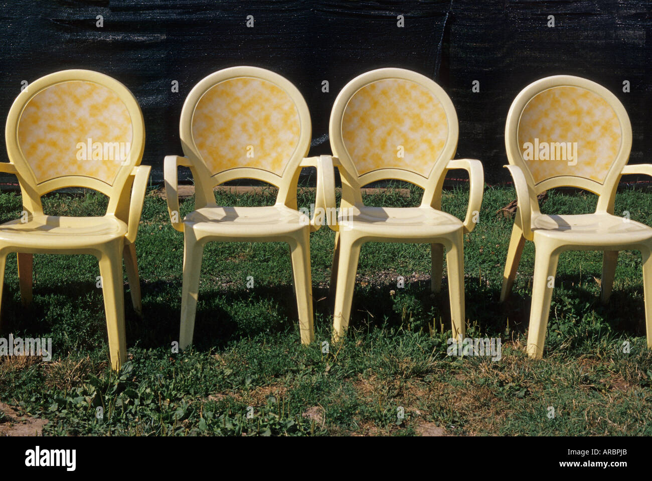 four yellow plastic chairs Stock Photo Alamy