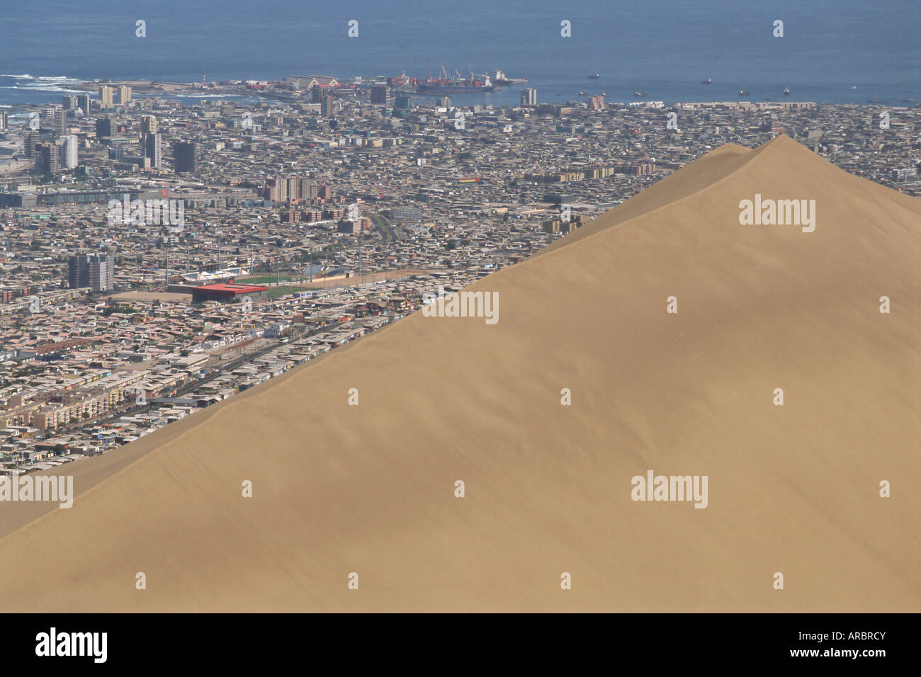 Giant sand dune above large city, Iquique, Atacama coast, Chile, South America Stock Photo