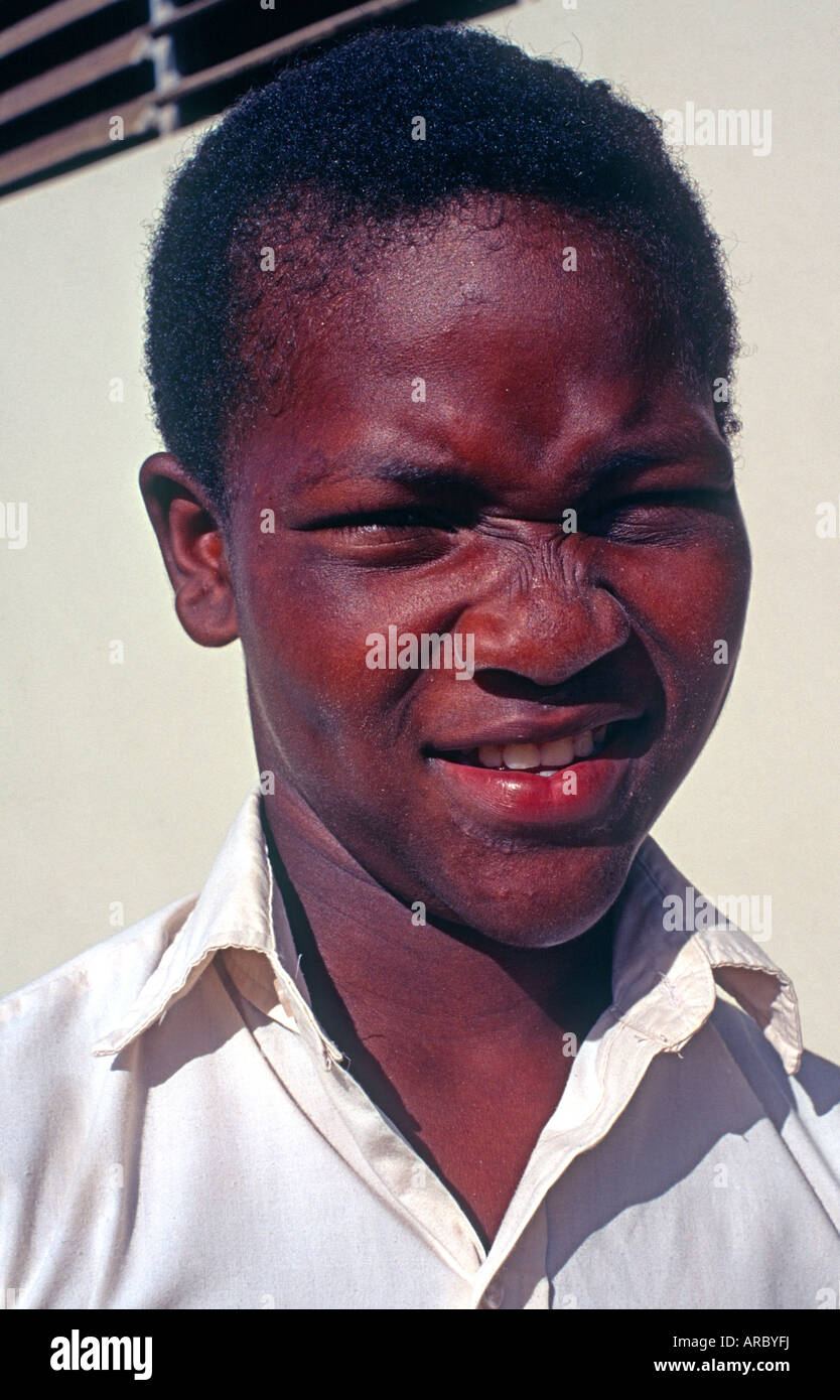 Jamaican boy portrait squinting in sunshine head and shoulders Cayman