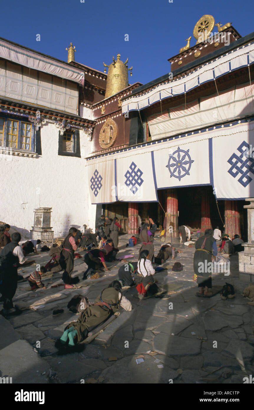 Tibetan Buddhist pilgrims prostrating in front of the Jokhang temple, Lhasa, Tibet, China, Asia Stock Photo