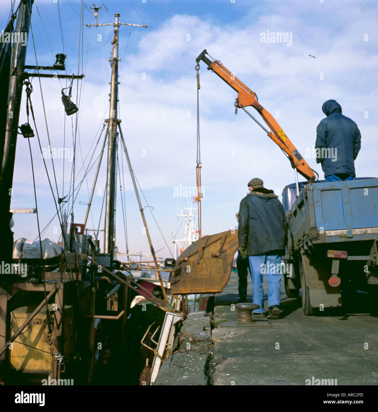 Small lorry mounted hydraulic crane being used to lift a trawl door, ship repair yard, Grimsby, North Lincolnshire, England, UK Stock Photo