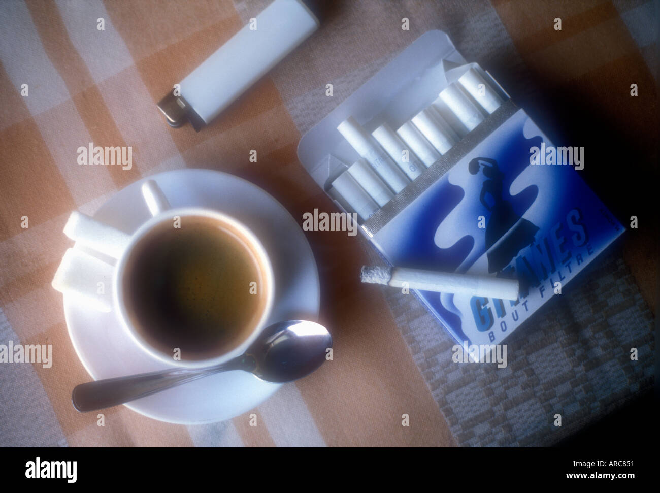 Still Life of Coffee and Gitanes cigarettes on cafe table in France Stock Photo