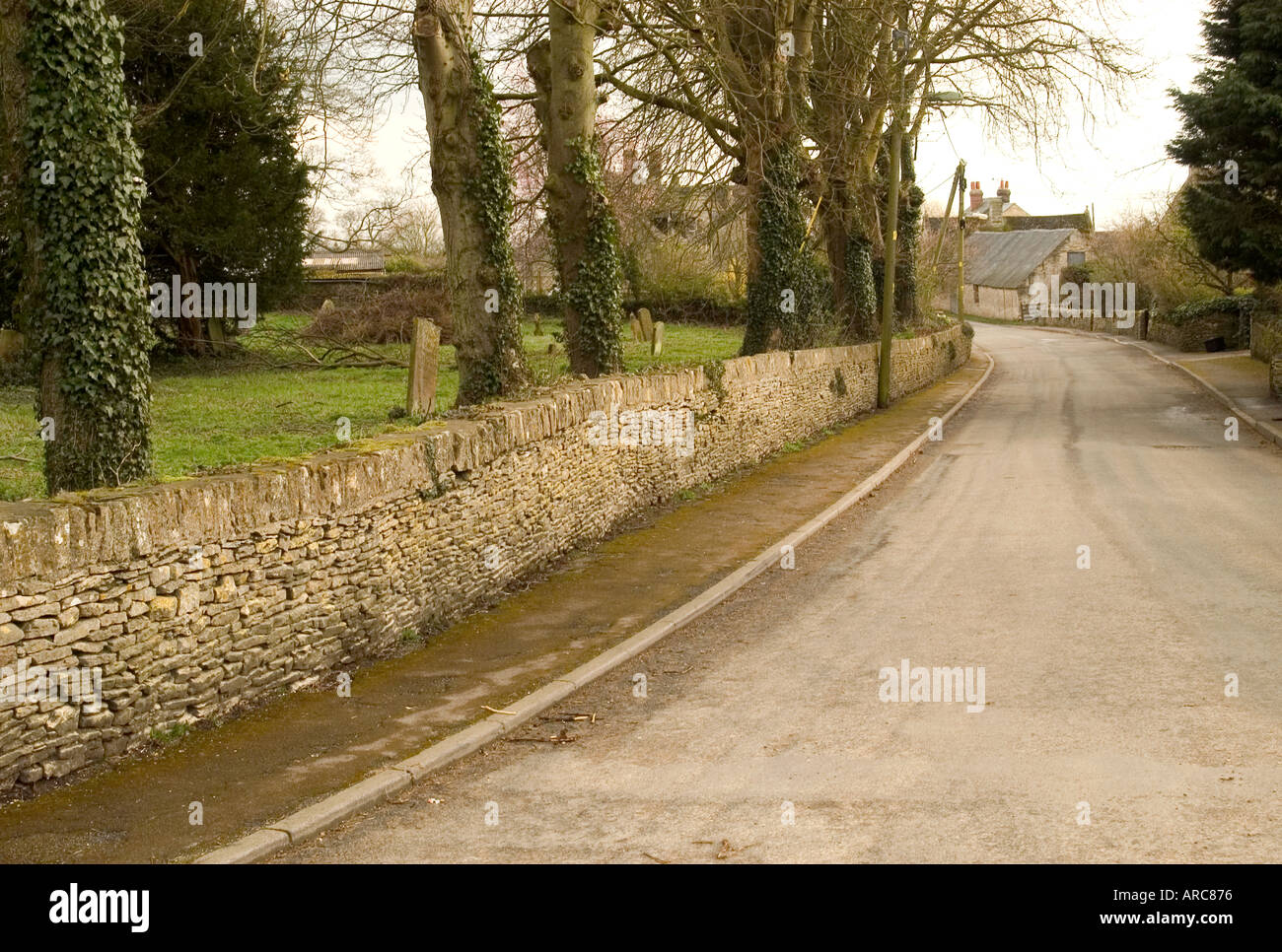 Country road by side of parish church in Leafield in Oxfordshire Stock Photo