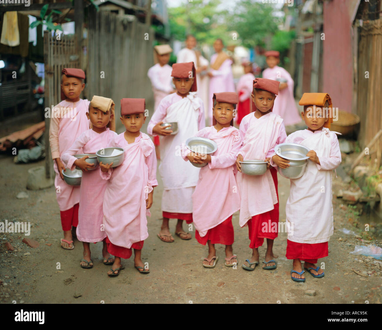 Young nuns with begging bowls, Mandalay, Myanmar, Asia Stock Photo