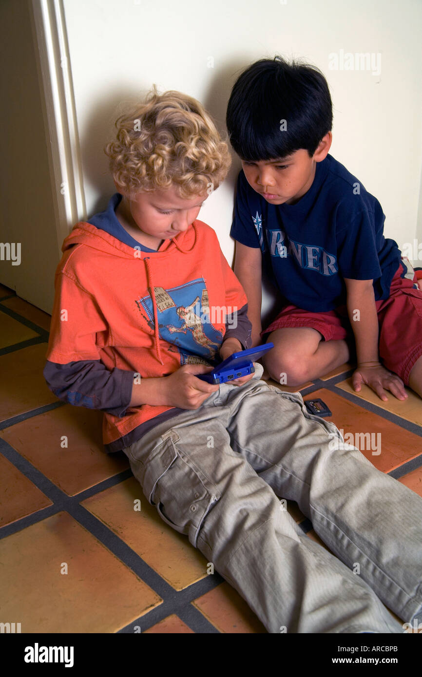 Two boys one Russian born and adopted the other Chinese American play a computer game together in Laguna Niguel CA Stock Photo