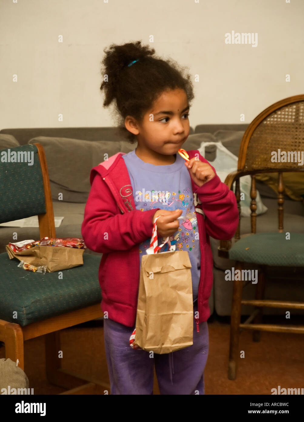 A little girl samples her candy a gift during Christmas activities for