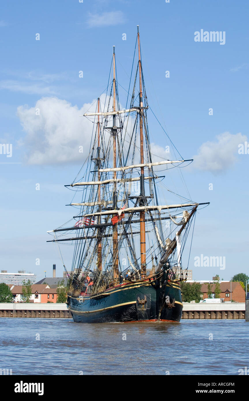 Tall ship The Bounty exits Alexander Dock at Kingston Upon Hull on the River Humber. She is shown under power with sails stowed. Stock Photo