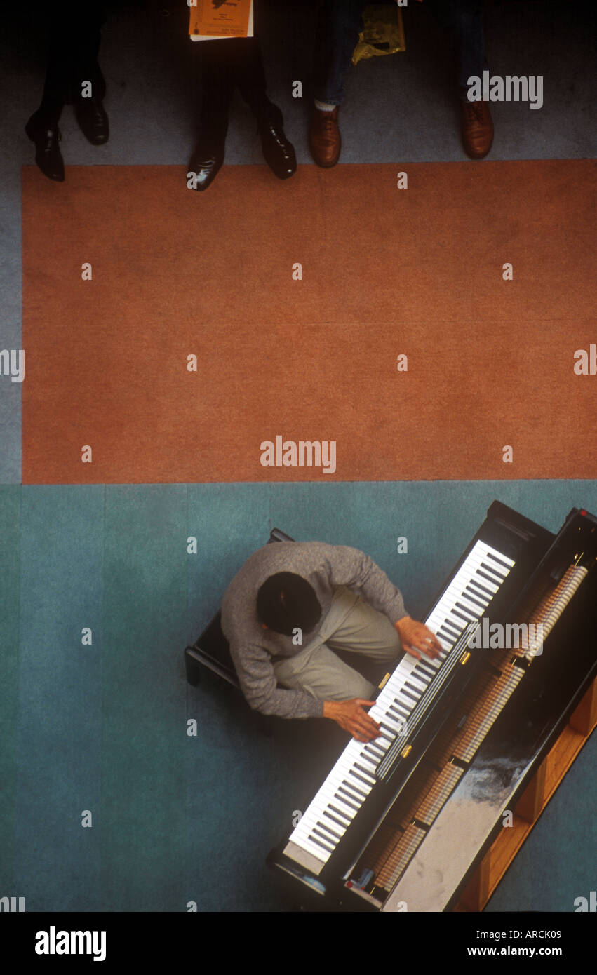 overhead view of pianist playing in foyer of Chelsea and Westminster hospital London UK Stock Photo