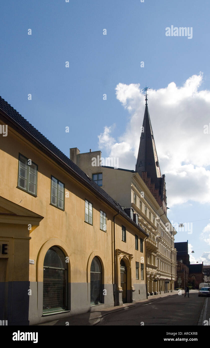 A street in Malmo Sweden with well-preserved buildings of older times with the spire of the mediaeval St Peters Church Stock Photo