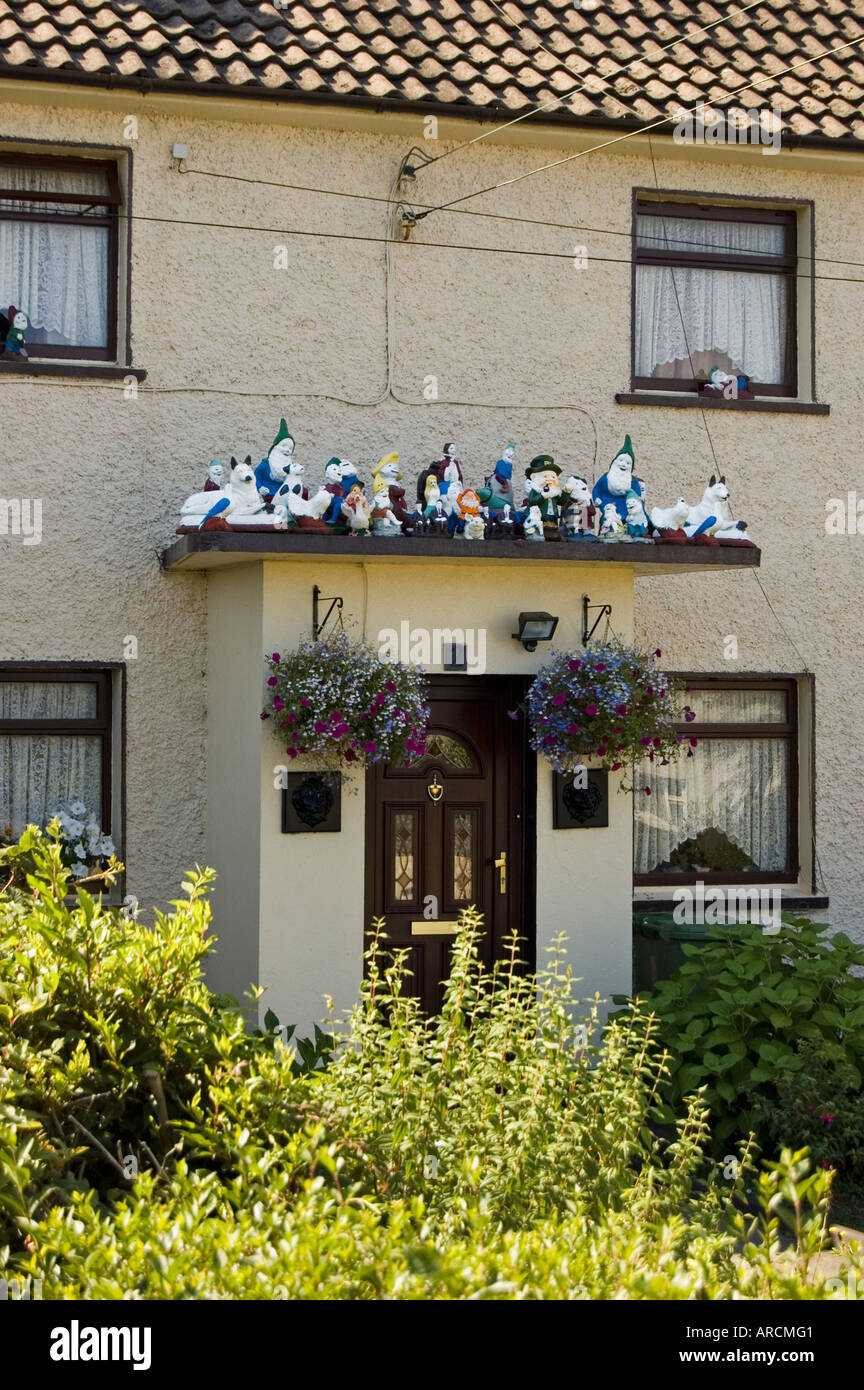 A collector of gnomes and garden ornaments placed these on the roof of his house porch - Dublin Ireland Stock Photo