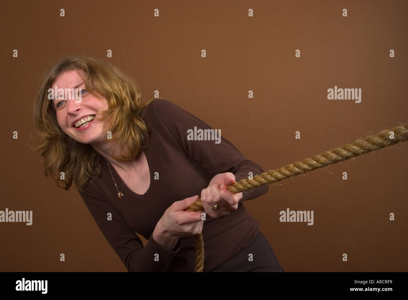 Young woman pulling on a rope Stock Photo - Alamy