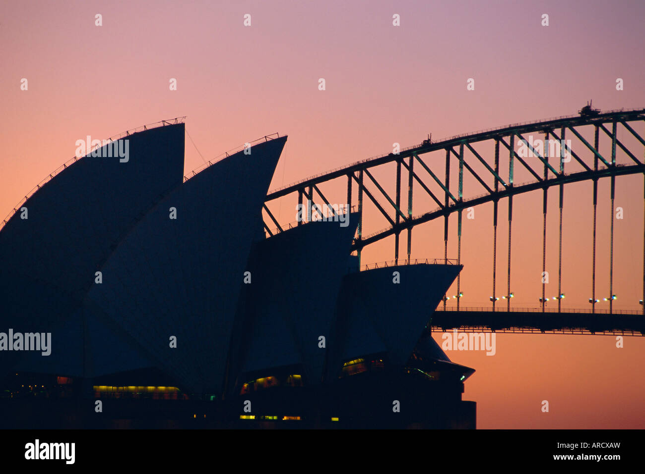 Sydney Opera House and Harbour Bridge silhouetted together at sunset ...