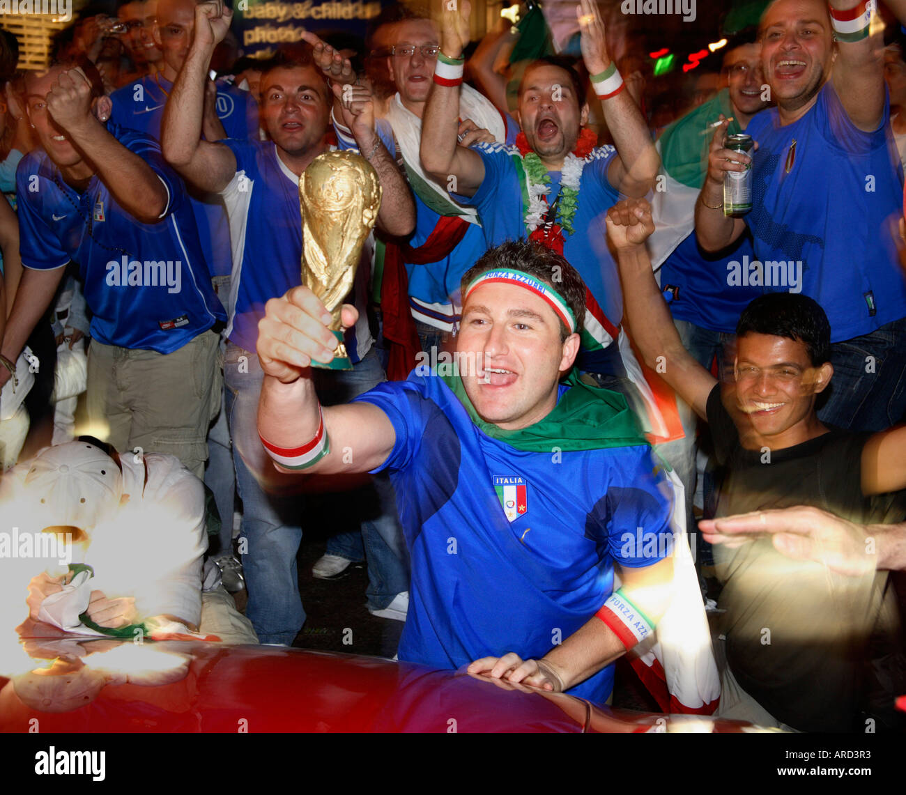 Italian fan shows off World Cup trophy to Ferarri driver in Piccadilly Circus after winning 2006 final vs France, London Stock Photo