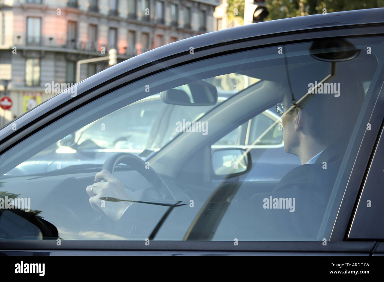 Businessman driving a fancy car in the town Stock Photo