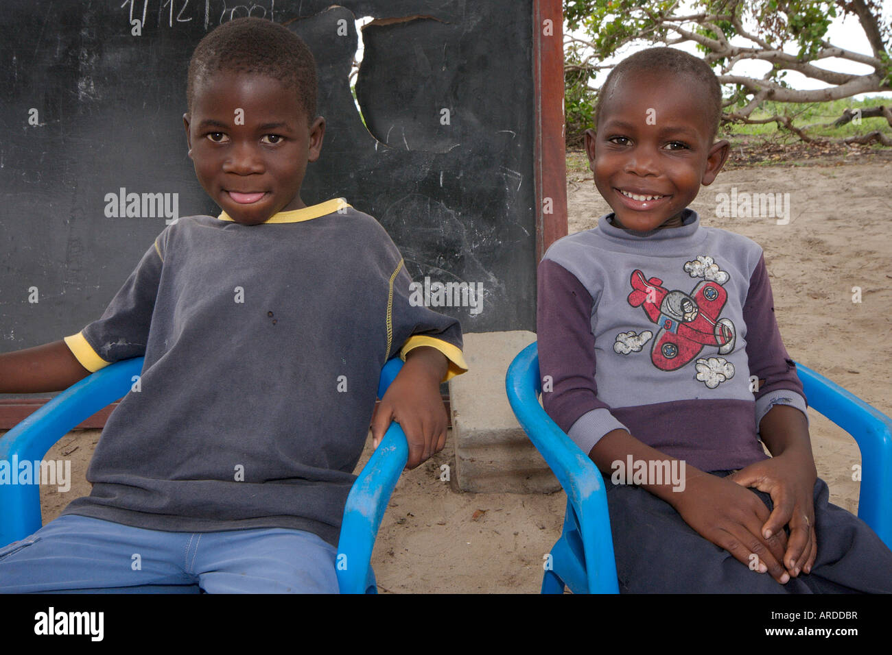 Volunteer teachers educate a class of Mozambican children in a bush ...