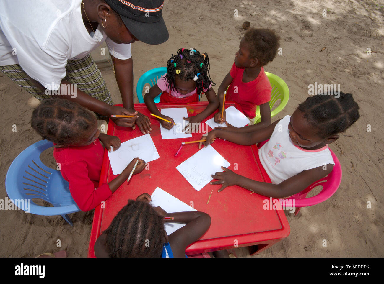 Volunteer teachers educate a class of Mozambican children in a bush ...