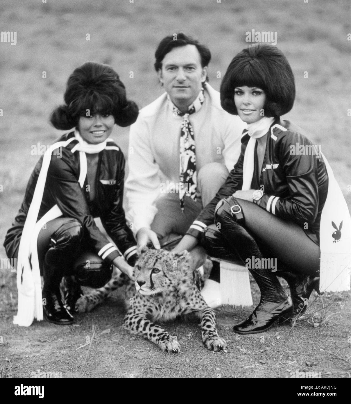 Hugh Hefner on safari in Kenya meeting an orphaned cheetah; his large entourage included Playboy Bunnies Stock Photo