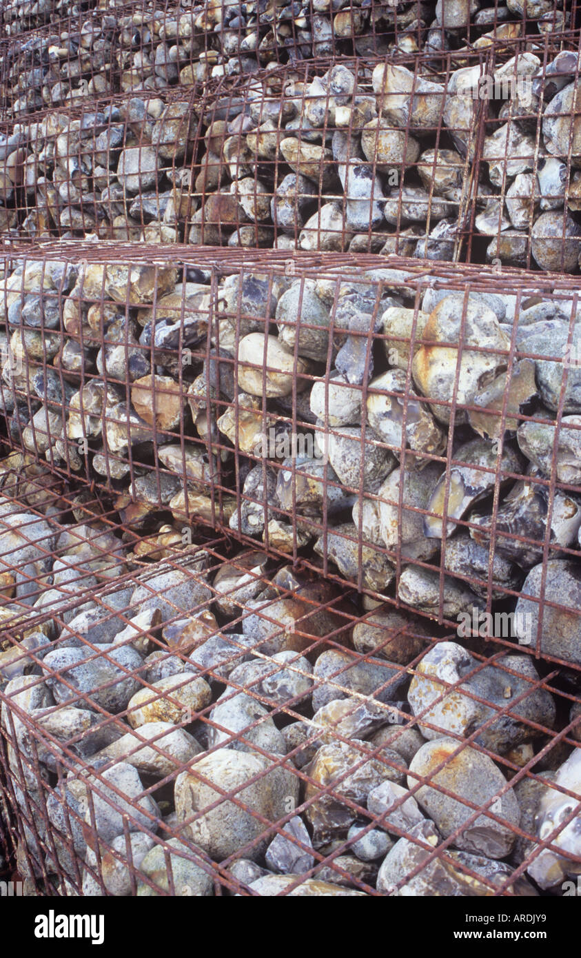Detail of wire cages or gabions containing large stones stacked and stepped as defence against coastal erosion Stock Photo
