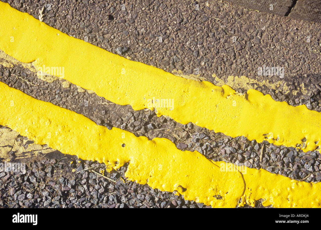 Detail from above of freshly painted double yellow lines following a curve in the road Stock Photo