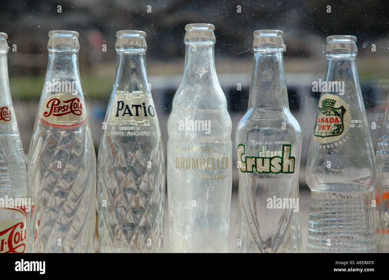 Vintage soda bottles stand in a saloon window in Wayne Alberta Canada