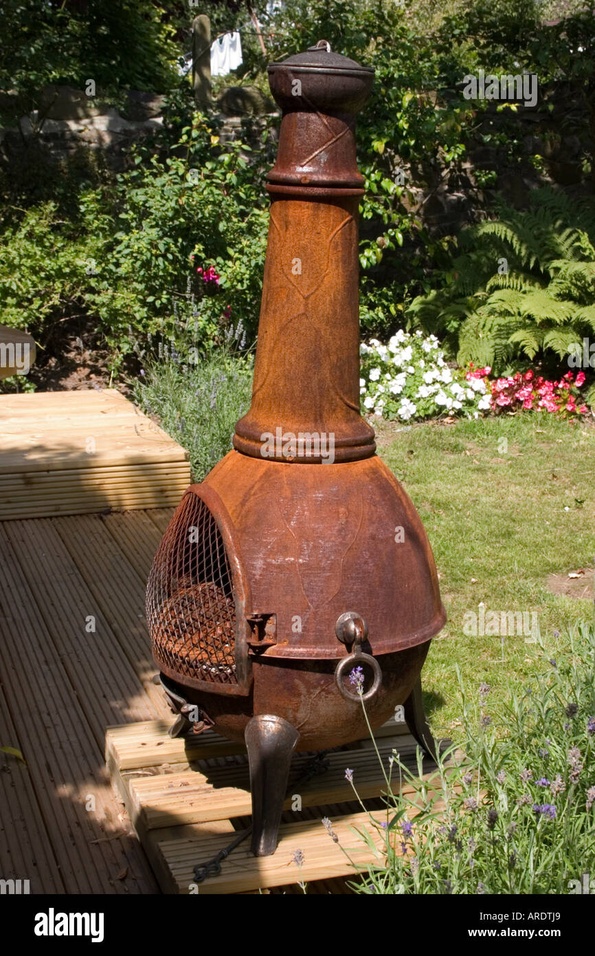 Garden chiminea covered in designer rust on wooden deck Stock Photo - Alamy