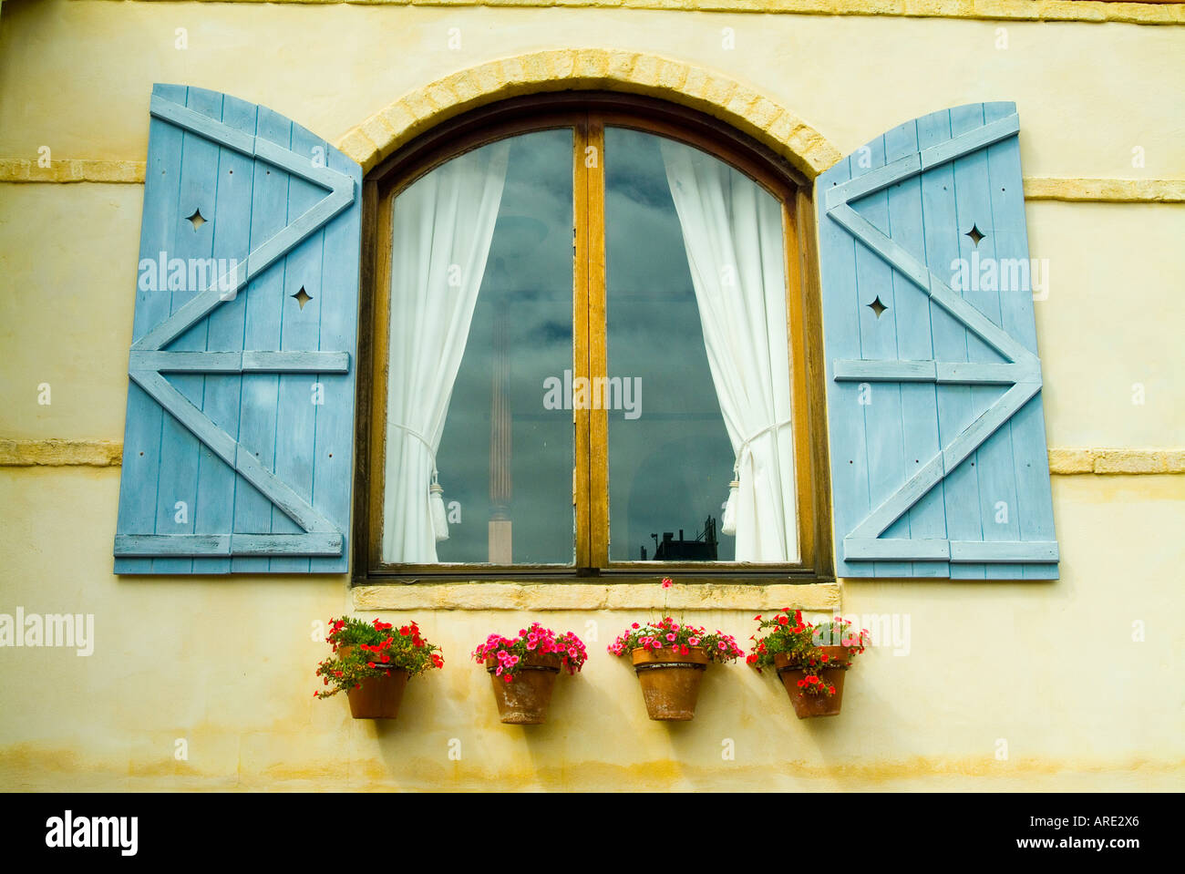 Shuttered window with flowerpots Stock Photo