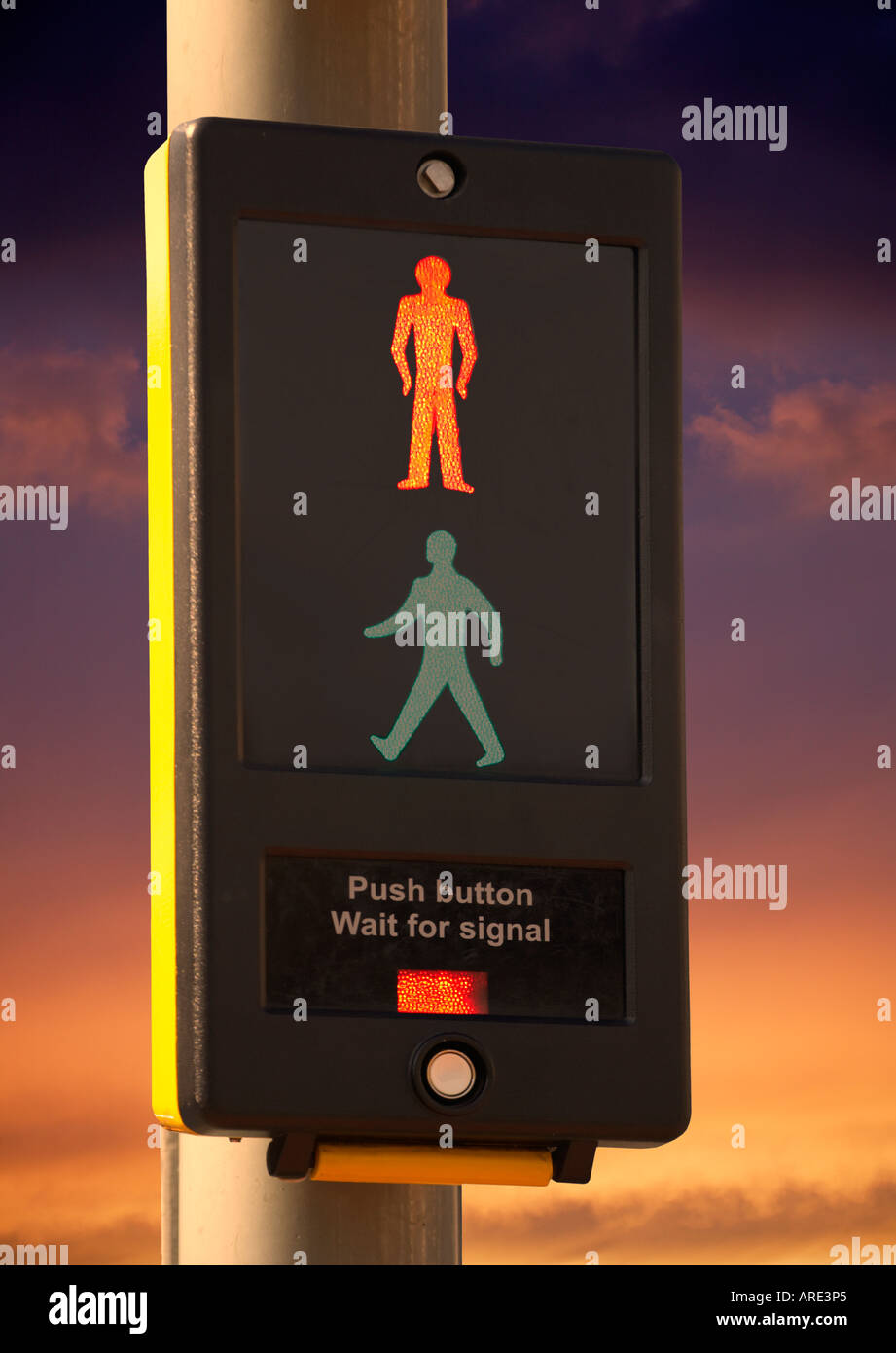 PEDESTRIAN CROSSING CONTROL BOX WITH ILLUMINATED ICON OF STANDING RED MAN AT TWILIGHT Stock Photo