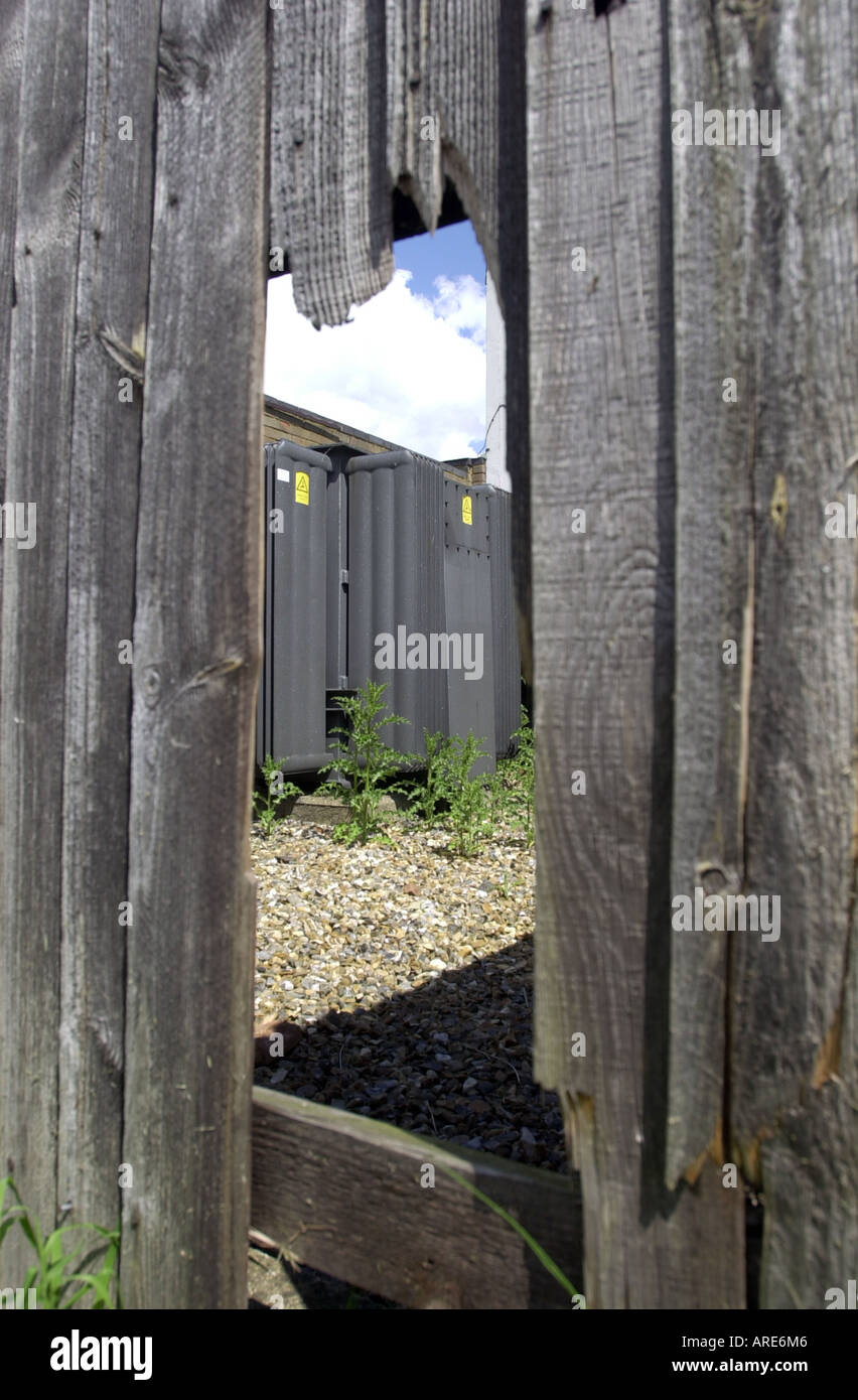 Damage to electricity sub station fence showing a wooden panel broken UK Stock Photo